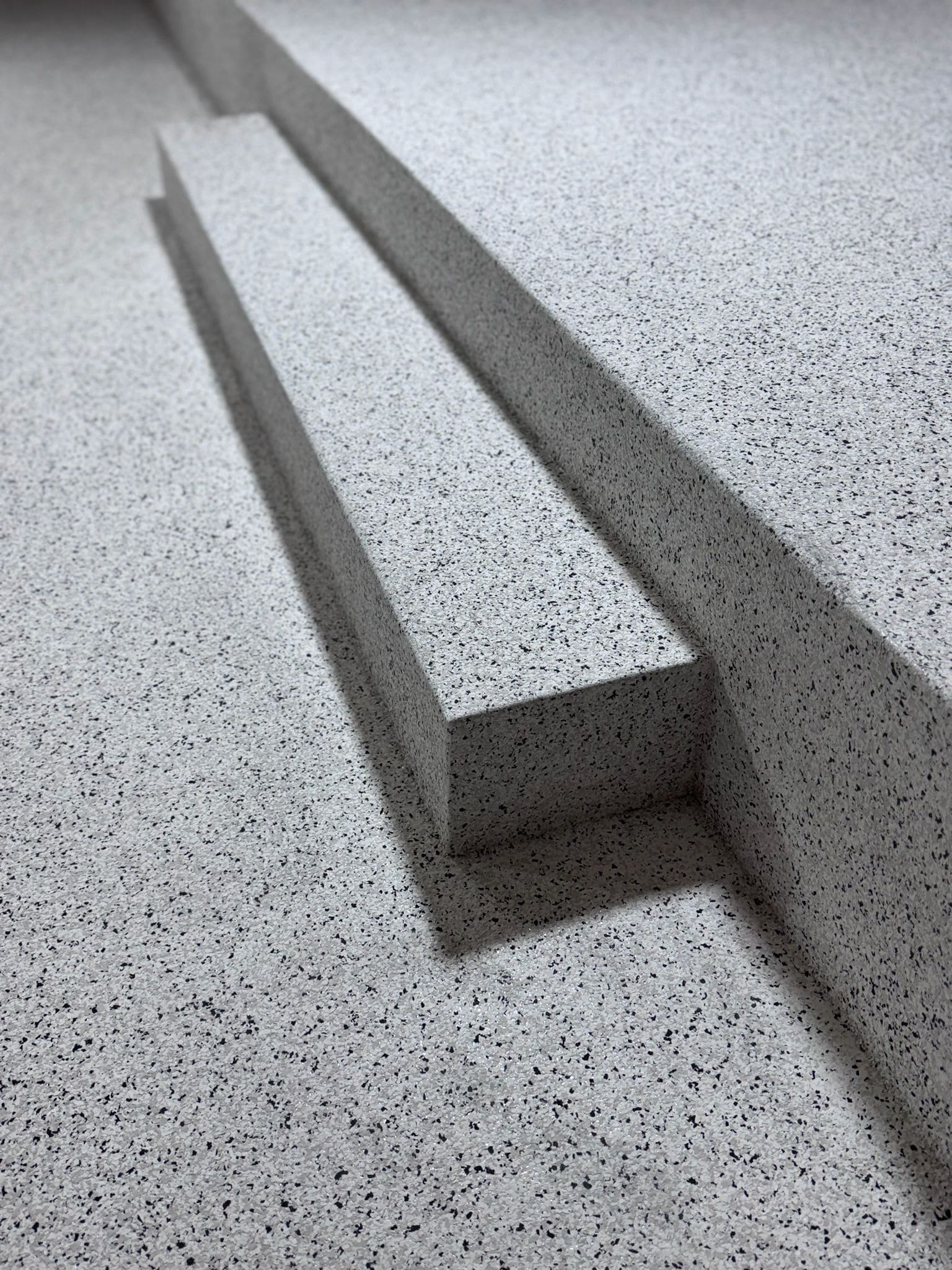Détail d'un sol en résine époxy gris moucheté à finition granitée Détail d'un sol en résine époxy gris moucheté à finition granitée